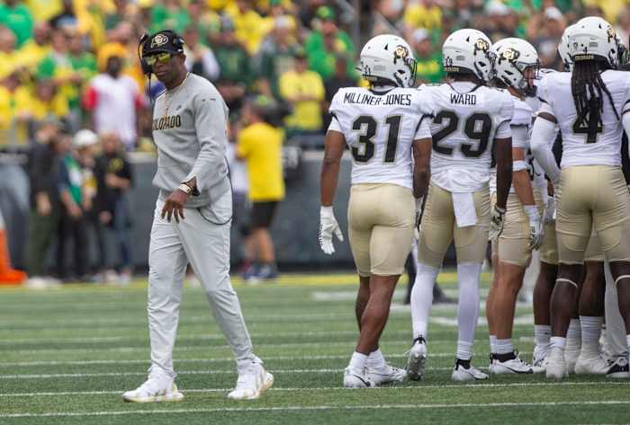 Colorado coach Deion Sanders leaves his team's huddle during timeout against Oregon.